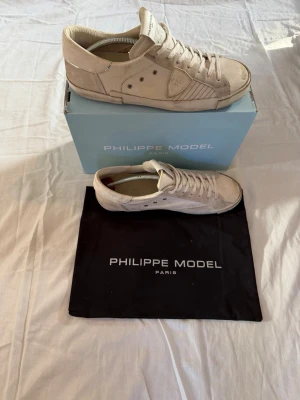 Philippe Model skor - Philippe Model Prsx low vita. Skorna har vita snören, diskret logotyp på sidan och detaljerade sömmar. Kommer med originalkartong och dustbag. Perfekta för en clean och stilren look. Storlek 45