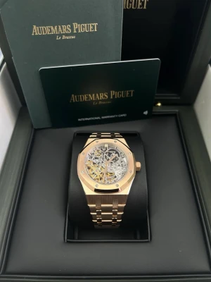 Audemars Piguet Royal Oak Skeleton rose gold  - Just nu kostar den 5000kr för att vi gjorde en prisäkning på 1000kr eftersom lådan saknas.                Den tickar inte det vill säga rör sig som originalet.                                                                                Lyxig Audemars Piguet Royal Oak Skeleton i roséguld med ikonisk oktagonal boett och genomskinlig urtavla som visar det mekaniska urverket. Länken är i matchande roséguld och klockan har en riktigt exklusiv vibe. Perfekt för dig som vill sticka ut med stil.
