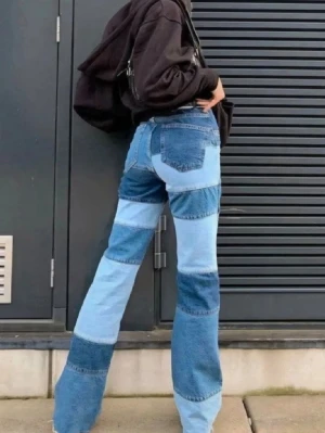 Patchwork jeans i olika blå nyanser - Unika patchwork jeans med hög midja och raka ben. Byxorna har flera olika blå denimtyger i blockmönster som ger en cool och trendig look. Perfekta för dig som vill sticka ut och gillar retrovibbar. Ingen stretch, klassisk femficksmodell.