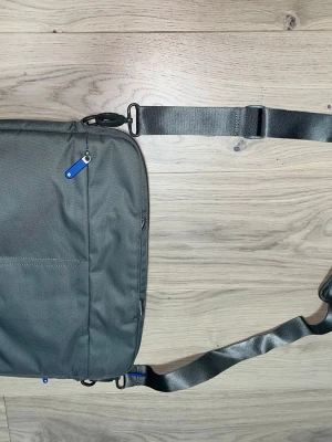 Mörkgrå datorväska med axelrem - Snygg mörkgrå datorväska, nästan helt ny. Va inte rädd att kontakta!