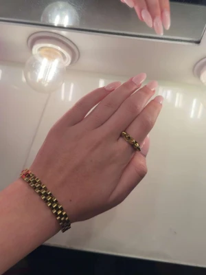 Guldfärgad chunky ring - Säljer en snygg guldfärgad chunky ring med geometriskt mönster. Ringen har en cool, modern design med markerade former som ger ett statement till din stil. Perfekt för dig som gillar accessoarer som sticker ut och vill addera lite edge till din look.