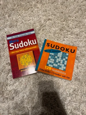 Sudoku - Säljer två sudoku-böcker: 'Mera Sudoku' med röd och gul framsida samt 'Sudoku på 10 minuter'. Båda innehåller massor av olika sudoku-pussel i varierande svårighetsgrad och tips för att lösa dem. Perfekt för dig som gillar hjärngympa och siffror. Helt oanvända. Har flera ute till försäljning och säljer gärna som paketpris🌸