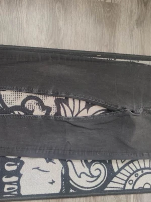 Svarta skinny jeans med hög midja - Säljer ett par svarta skinny jeans med hög midja och klassisk femficksdesign. Jeansen har smal passform och är tillverkade i stretchigt denimtyg för extra komfort. Perfekta till en avslappnad streetstyle-look.