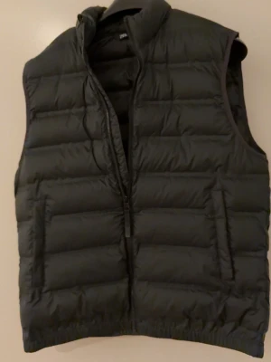 Svart dunväst från Zara - Snygg svart dunväst från Zara med quiltad design och hög krage. Västen har dragkedja framtill och två sidofickor. Använd 1 gång vid köp men annars aldrig igen eftersom jag ångra att jag köpte den.
