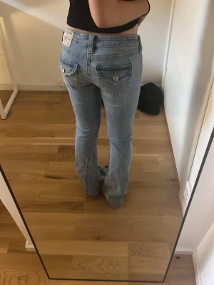 Ljusblå bootcut jeans från True Religion - Säljer ett par ljusblå bootcut jeans från True Religion. Jeansen är helt som nya förutom att dem är uppsydda! Så dem passar om man är mellan 158-165. 