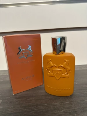 Parfums de Marly Althaïr EdP - Exklusiv parfym från Parfums de Marly, Althaïr EdP. Flaskan är matt orange med reliefdetaljer av två hästar och en silverfärgad, tung kork med ingraverad logga. Kommer i matchande orange kartong med silverdetaljer. Lyxig och unik design som sticker ut i parfymhyllan.