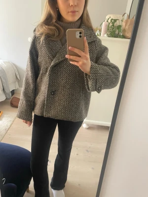 Brunmelerad kort kappa med krage - Snygg brunmelerad kappa med bred krage och dubbelknäppning. Storlek XS men passar mig som brukar bära S utmärkt. Nypris ca 1100💕Använd ca 3 gånger