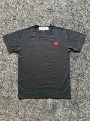 Svart CDG PLAY t-shirt - Säljer en svart t-shirt från Comme des Garçons PLAY med det ikoniska röda hjärtat broderat på bröstet. Storlek 