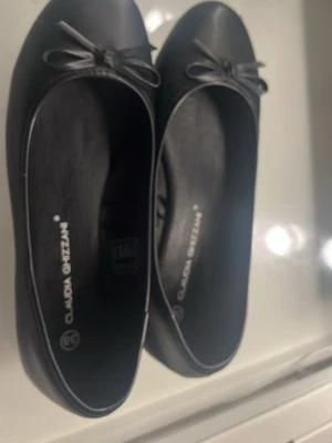 Svarta ballerinaskor med rosett - Ett par svarta ballerina skor aldrig använda. Köpt nya för ett par hundra