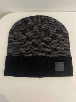 Mössa för dej som vill se lite stilig ut  - En svart grå rutig mössa.