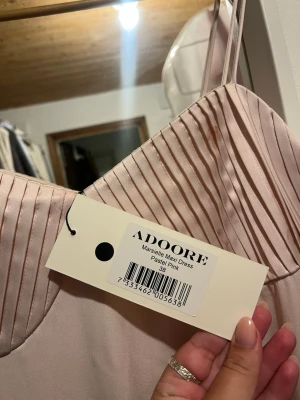 Adooreklänning - utgått sortiment - Ny Adoore-klänning med prislapp – utgången modell i puderrosa satin med smickrande passform. Storlek 38. Perfekt till bröllop & sommarfester.