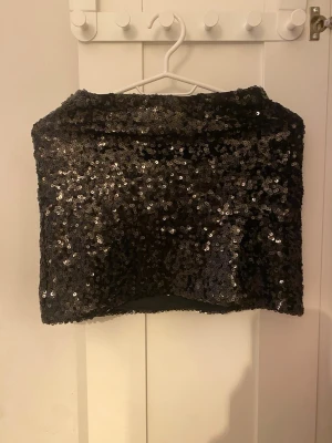Svart glittrig kjol - Glittrig svart kjol täckt med paljetter som ger ett riktigt statement-utseende. Perfekt för dig som vill sticka ut och glänsa