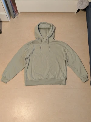 Tröja med huva - Tröja med huva . Bifogar en bild på en liten fläck längst ut på ena ärmen, även en liten färg skillnad längre ner på framsidan av tröjan, en färg skillnad på huvan i form ett sträck. Tvättas i 40 grader, 69 % bomull och 31 % polyester 