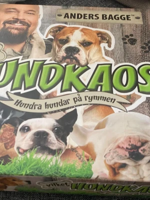 Sällskapsspel Hundkaos av Anders Bagge - Roligt sällskapsspel med hundtema där du ska samla så många hundar som möjligt. Spelet innehåller spelplan, tärning, hundar, plastfötter, frågekort, händelsekort, hundkort, klistermärken, hundgårdar, parkbänkar och regler. Perfekt för hundälskare!