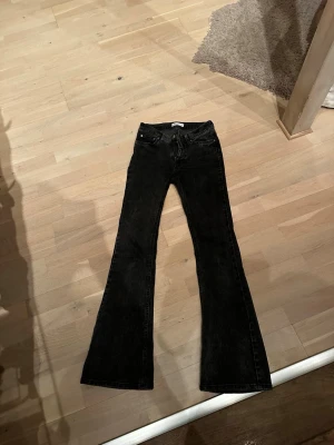 Mörkgråa bootcut jeans  - Säljer ett par mörkgråa jeans med bootcut passform och klassisk femficksdesign. Jeansen har en lätt tvättad look och silverfärgad knapp. Perfekta till en avslappnad stil och passar till det mesta i garderoben. Köpare står för frakt. Skriv vid frågor eller intresse💗