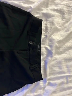 Svarta mini shorts - Säljer ett par svarta mini shorts och två knappar framtill. Perfekt för fest och använda en gång