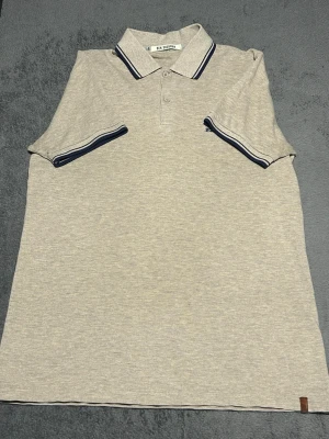 Ben Sherman Polo Shirt – Beige – Size S – Mod Style - Klassisk piké från Ben Sherman i beige färg med mörkblå kontrastdetaljer på krage och ärmar.  En tidlös modell inspirerad av brittisk mod-stil, perfekt till jeans eller chinos.  Detaljer • Ben Sherman • Beige / sand färg • Kontrastdetaljer på krage och ärmar • Broderad logga • Storlek S  📦 Skickas snabbt 💬 Hör av dig vid frågor