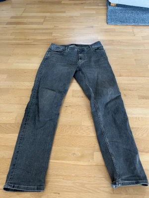 Grå  jeans från Mango  - Säljer ett par grå jeans med rak passform. Jeansen har normal midja och dragkedjegylf. Materialet är denim i bomull och färgen är tvättad grå, vilket ger en avslappnad look.