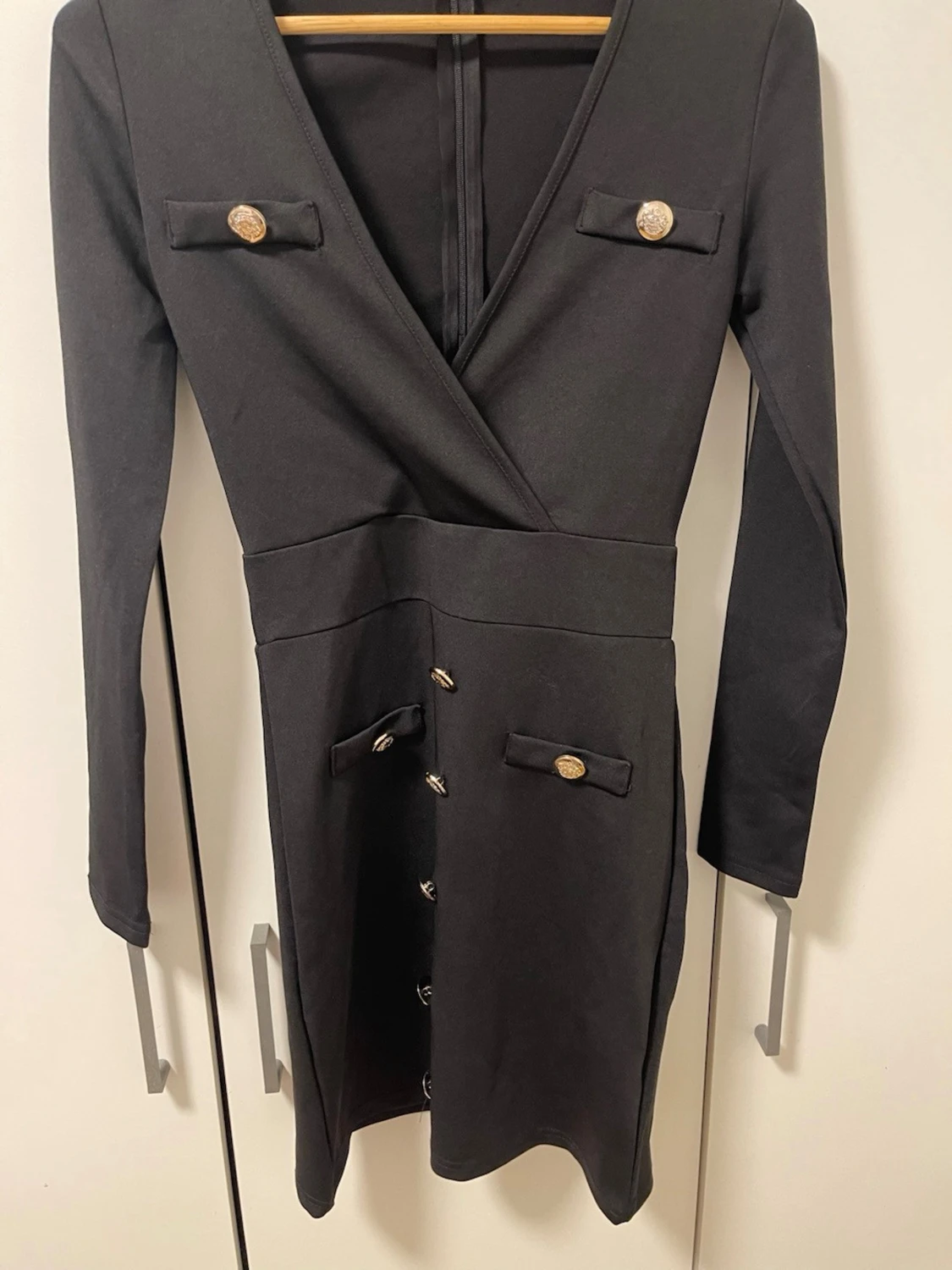 Svart omlottklänning med guldknappar