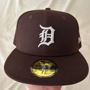 Brun New Era 59Fifty Keps - Snygg brun keps från New Era, modell 59Fifty Detroit Tigers. Platt skärm och normal passform. Storleken är 57.7 cm eller 7 1/4. Säljer eftersom den blev för liten.