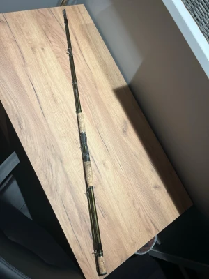 BFT roots g2 170g multi fiskespö - Säljer ett fiskespö i grön metallic färg med handtag i kork och detaljer i svart plast. Spöet har flera ringar för linan och är delbart på mitten. Perfekt för dig som gillar fiske och vill ha ett klassiskt spö som man kan kasta tunga drag med även ensnygg design.