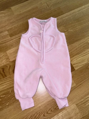 Bebisoverall stl 56 - Rosa fluffig overall från KAXS (Kappahl) i storlek 56. Mycket bra skick.  Från djur- och rökfritt hem.  Tvättat med parfymfritt tvättmedel, inget sköljmedel. ☺️