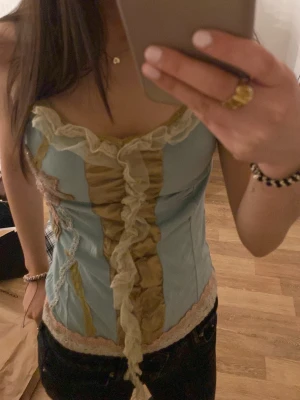 detaljrikt linne - ett ljus blått linne med mycke detaljer o krim krans, passar väldigt bra o passande till ens kroppsform