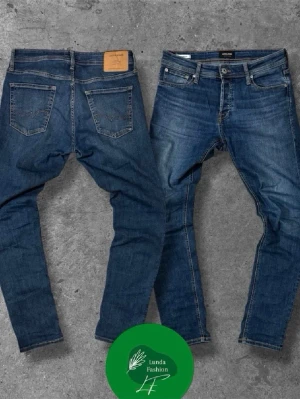 Blå slim fit jeans från Jack & Jones - Snygga blå slim fit jeans från Jack & Jones med klassisk femficksdesign och normal midja. Jeansen har en lätt tvättad look, gylf med knapp och dragkedja samt detaljerade sömmar. Perfekta för en trendig och avslappnad stil.