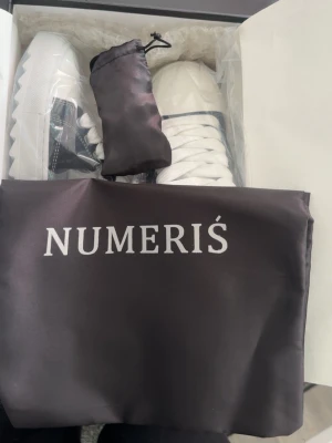 Trendiga sneaakers from Numeris  - Snygga sneakers från NUMERIS i svart och vitt med vita snören och kontrastsömmar. Ovandelen är i slätt och texturerat syntetmaterial, och sulan är vit med räfflad kant. Klassisk låg modell som passar till många stilar. Storlek 42, kom gärna med prisförslag. Skorna har använts vid få tillfällen och det syns