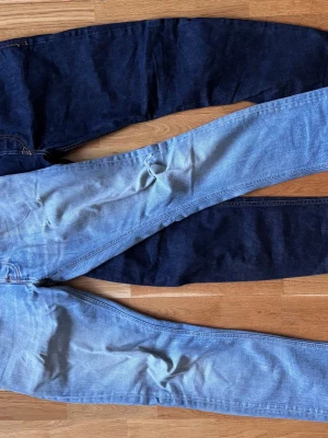 Två par jeans i blå denim - Säljer två par jeans i ljusblå med slitningar och ett par i mörkblå. Ljusblåa är från Nudie jeans och andra paret är från Desiel. Diesel jeansen är W30 L32. Nudie jeansen är W29 L32, men skulle säga att de passar W30. Hör av er vid frågor!