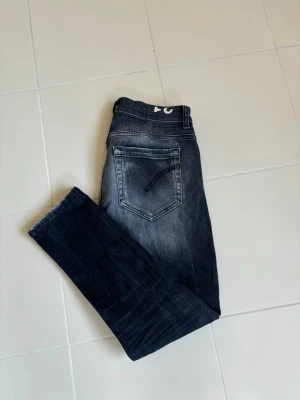 Otroliga stentvättade dondup George jeans w31 - Superfina snygga eleganta och eftertraktade grå svarta Dondup jeans i w31 (41 cm breda och 94 cm total längd). Brutalt unik schyst tvätt som nya och inga hål eller fläckar! Tveka inte vid minsta fråga eller fundering och pris ej hugget i sten.