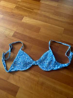 TVÅ bikini överdelar för 50 kr - Jag säljer dessa två olika bikini topparna för 50 kr och båda två är från SHEIN för de som undrar,den första är använd ett par gånger och den andra har aldrig använts.Söt bikiniöverdel i blått med vitt blommönster. Triangelformade kupor med smockdetaljer och justerbara axelband.  Lila bandå bikini överdel. Den blåa bikini överdelen är i storlek M och den andra i storlek S