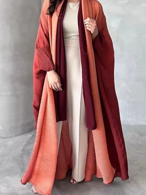 Plisserad lång kofta i vinrött och orange - Säljer en plisserad lång kofta i vinrött och orange med vida ärmar och öppen front. Koftan har ett elegant fall och finns i flera färger. Perfekt för att lyfta din outfit med en trendig touch.