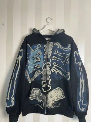Cactus Jack X Fragment Hoodie - Cactus Jack X Fragment hoodie i väldigt bra skick med dragkedja och huva med ett stort skelettmönster i vitt, blått och grått både fram och bak.