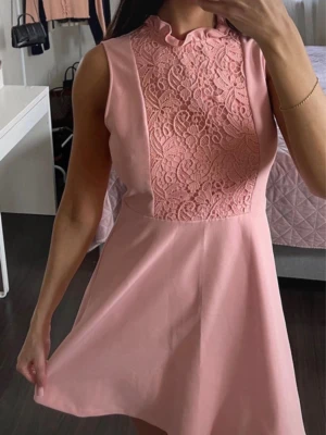 Rosa ärmlös klänning med spets - Söt rosa klänning med ärmlös design och vacker spetsdetalj framtill. Klänningen har en kort längd och en lätt utsvängd kjol. Perfekt för dig som gillar feminina och stilrena plagg med fina detaljer.storlek är M men kan även passa fint på S.från Zara woman.