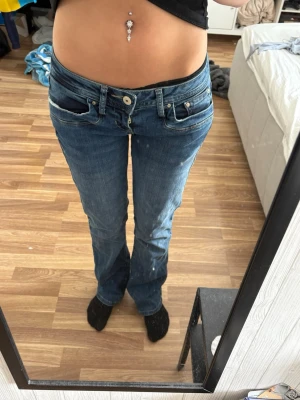 Blå bootcut jeans från LTB - Säljer ett par blå bootcut jeans från LTB med låg midja och klassiska fem fickor. Jeansen har snygg bekväm passform som sitter tajt upptill och släpper nedtill. Perfekta för dig som gillar en avslappnad men trendig stil. Helt oanvända!