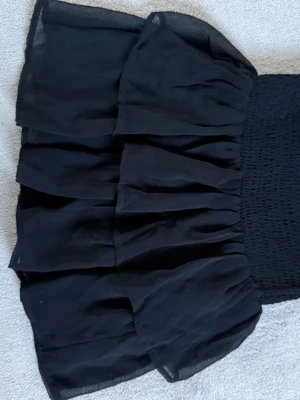 Black Ruffle Mini Skirt - 🖤 Black Ruffle Mini Skirt – Trendy Winter Outfit 🖤  Cute black layered mini skirt with soft flowy fabric and stretchy waist for a comfortable fit ✨ Perfect for winter outfits with tights, boots, oversized sweaters, or a leather jacket. Super trendy Y2K / coquette style and easy to dress up or down.  ✨ Brand: Design by KappAhl ✨ Size: 146/152 ✨ Color: Black ✨ Condition: Good ✨ Stretchy waistband & layered design  Perfect for parties, holidays, casual outfits, or aesthetic fashion looks ❄️