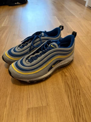 Nike Air Max 97 - Nike Air Max 97 – Storlek 42.5 Knappt använda och i superbra skick! Gråa med snygga blå och gula detaljer – en klassiker från Nike.  Storlek: 42.5 Färg: Grå med blåa och gula detaljer Skick: Nästan som nya! Varumärke: Nike Air Max 97 – ikoniska och komfortabla. Varför du kommer att älska dem:  Snygg färgkombination som verkligen sticker ut. Supersköna och perfekta för både vardag och träning. En riktig klassiker som aldrig går ur stil.