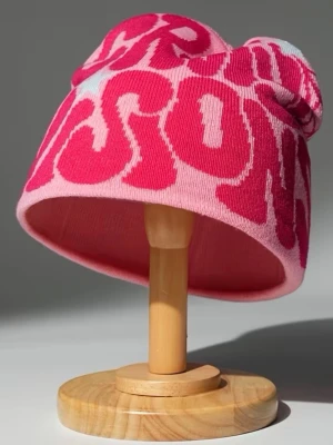Rosa mössa med grafiskt tryck - Cool rosa mössa med stort grafiskt textmönster i olika nyanser av rosa. Mössan har en avslappnad passform och är stickad i mjukt material, perfekt för att ge din outfit en färgklick. Passar dig som gillar streetstyle och vill sticka ut.