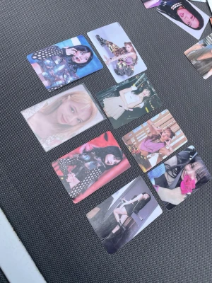 K-pop photocard samling - Säljer ett set med nio K-pop photocards med olika motiv på kvinnliga idoler. Korten är i färg och har rektangulär form, tryckta på glansigt papper. Perfekt för dig som samlar på K-pop merch eller vill dekorera ditt skrivbord eller vägg. Flera olika outfits och poser.