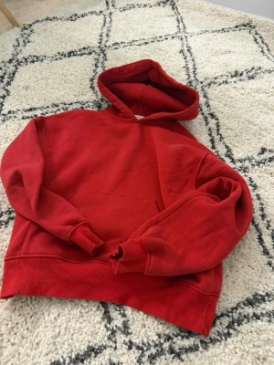 Röd hoodie med huva - En klassisk röd hoodie med stor huva och magficka. Hoodien har ribbade muddar vid ärmslut och nederkant. Perfekt för en avslappnad och chill stil. Materialet känns mjukt och bekvämt, troligen bomull eller bomullsblandning. (Skriv för mer bilder💕)
