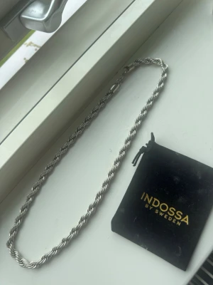 Silverfärgat repkedje-halsband Indossa - Säljer ett stilrent halsband från Indossa by Sweden i silverfärg. Halsbandet är 60 cm långt och är silverplaterad. 8mm tjockt