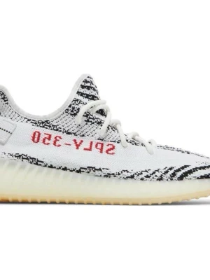 ÄKTA Adidas Yeezy Boost 350 V2 Zebra Sneakers Vit Boost Kanye West Ye Sneakers - Adidas Yeezy Boost 350 V2 skor  Skick: Fint  Färg: Zebra  Strl: 44 (28 cm)  Info: Äkta. Köpta i Sverige.  Adidas Yeezy Boost 350 V2 Zebra är en populär sneaker med en iögonfallande design. Skon har en ovandel i Primeknit med ett zebramönster i svart och vitt, kompletterat med en röd "SPLY-350"-text på sidan. Mellansulan är utrustad med Adidas responsiva Boost-teknologi, vilket ger utmärkt komfort och stötdämpning. Yttersulan är i gummi för bra grepp. En dragflik på hälen underlättar på- och avta