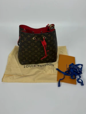 Louis Vuitton Noe Bandouliere  - LV Noe - som ny med dustbag osv. Nypris 21500kr vårt pris 8590kr, fler bilder kan skickas. Fantastisk väska, i deras klassiska canvas monogram med röd mocka interiör 