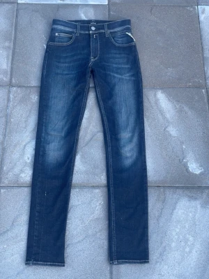Replay jeans  - Tjena!!! Säljer ett par Snygga mörkblå slim jeans från Replay med klassisk femficksmodell och vita kontrastsömmar. Jeansen har en lätt tvättad look med slitningar på låren och raka ben. Perfekta för en trendig och avslappnad stil. Storlek 14A (barnstorlek) passar kanske folk från 155-165 kanske. Skick 9,5/10, modell super slim hyperflex!! Hör av dig vid mer frågor eller funderingar🤩🕺mvh Ga