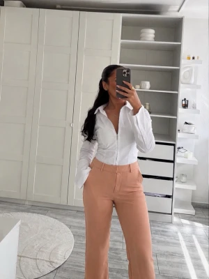 Beige/Rosa kostymbyxor med vida ben – Trendiga & elegantaBeige/Rosa kostymbyxor med vida ben – Trendiga & eleganta - Säljer ett par supersnygga kostymbyxor i en fin beige/ljusrosa nyans. Modellen har raka, lätt vida ben och en hög midja som ger en elegant och smickrande passform. Perfekta till kontoret, middagar, vardag eller en mer uppklädd look tillsammans med skjorta, topp eller blazer. 