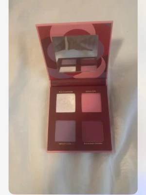 Fyra nyanser ögonskuggspalett rosa/lila - Säljer en fyrkantig ögonskuggspalett med fyra nyanser: skimrande ljusrosa, matt rosa, ljuslila och mörkare burgundy. Paletten har spegel i locket och kommer i en röd-rosa förpackning. Perfekt för kreativa ögonlooks.. från Mary kay