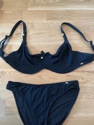 Twilfit Bikini Full Support Change, St 70F/36 - Från Twilfit modellen Marisol Full Support Trosorna är Tai modell  Bh: Klassisk neutral svart full shaper som är perfekt för den med lite större byst. Perfekt för dig med större byst  • Klassisk midjeresilhuett  • Mjuk midjeband för en jämn passform  • Något högre bensnitt för en smickrande form  • Fullt fodrad för komfort och självsäkerhet   Bhn i storlek 70F och underdelen 36  Använda endast en gång så i perfekt skick och redo för nya användare