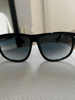 Svarta Ray-Ban Wayfarer solglasögon - Snygga svarta  solglasögon från Ray-Ban med klassisk fyrkantig form och mörka glas. Perfekta för att lyfta din stil och skydda ögonen mot solen. Ikonisk logga på linsen och robust båge i plast. Box medföljer ej!