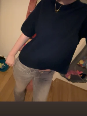 Mörkblå t-shirt med kort ärm - En enkel mörkblå t-shirt med korta ärmar och rund hals. T-shirten har en loose passform och är perfekt för en clean och avslappnad stil. Passar till både jeans och kjol.